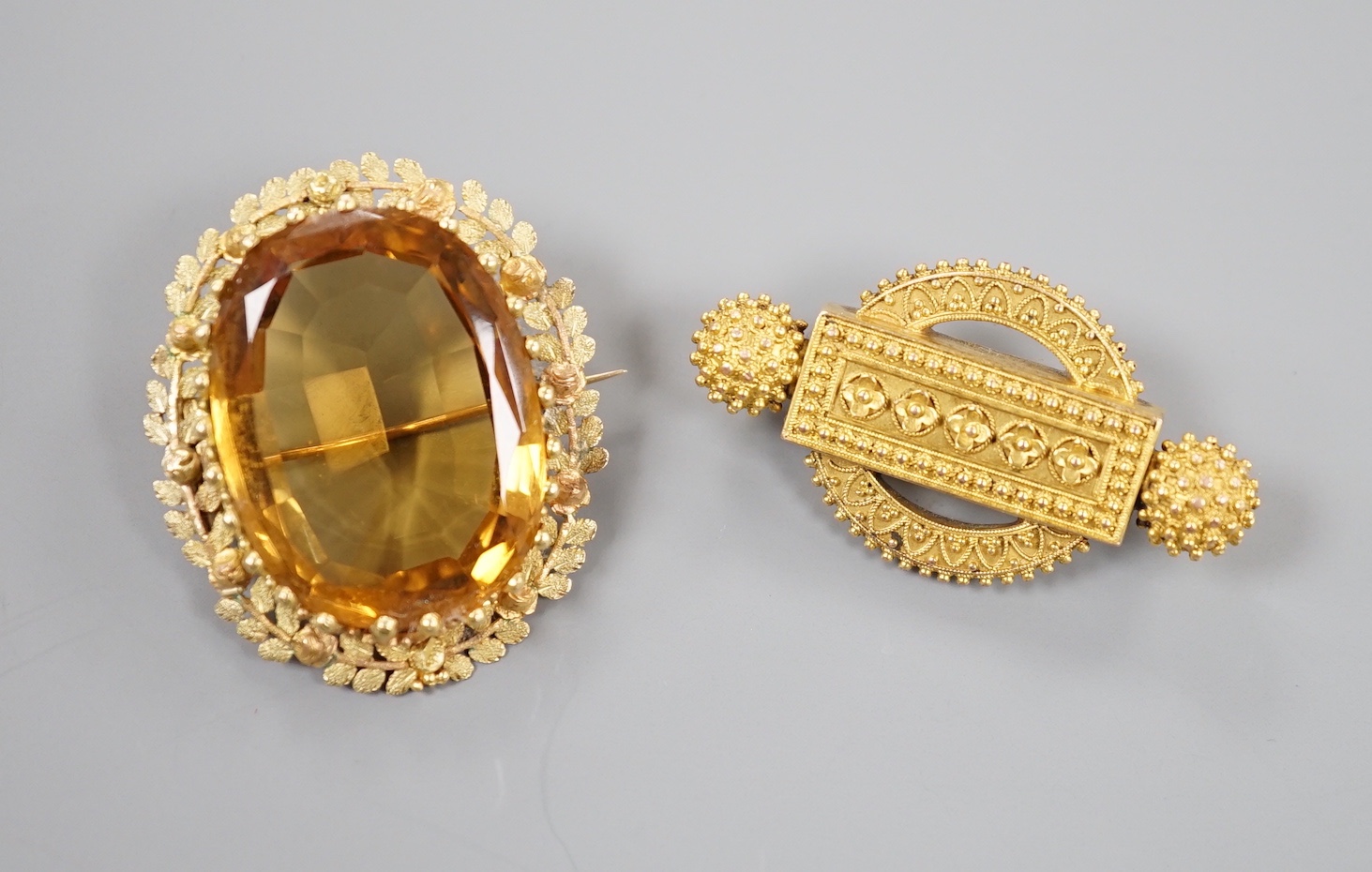 Two Victorian yellow metal brooches, one set with large oval citrine, largest 36mm, gross 19.2 grams.